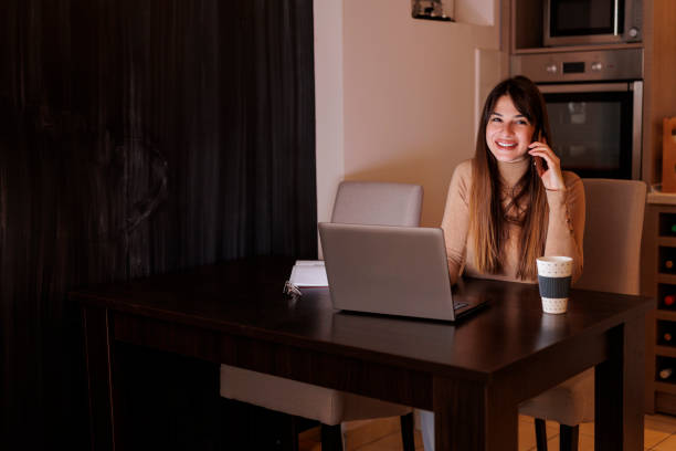 istock Woman having phone conversation while working late from home 1401072859
