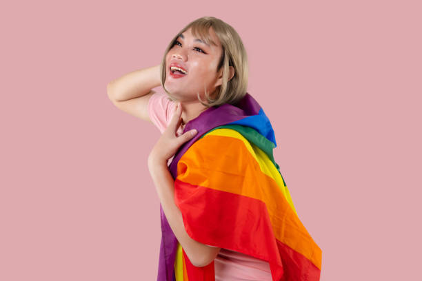 레인보우 깃발을 가진 젊은 아시아 트랜스젠더 lgbt는 핑크색 배경에 고립되어 있습니다. 성 표현 자부심과 평등 개념. - sex object 뉴스 사진 이미지