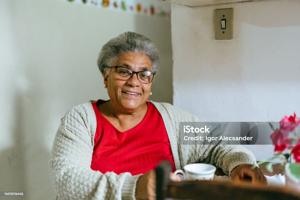Smiling elderly woman drinking coffee at home Senior Adult Stock Photo