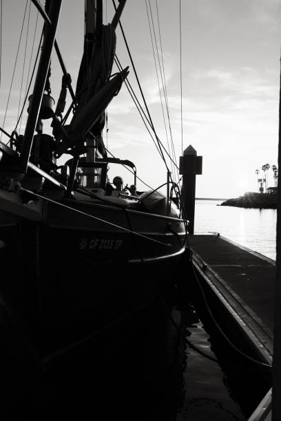Black and white photograph of fishing boats docking at Ban Na Kluea Pier, Thailand.