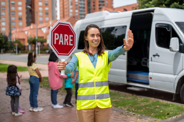 istock Crossing guard holding a STOP sign in Spanish 1401090536