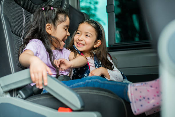 istock Two happy girls playing while riding in the school bus 1401090546