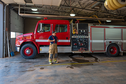 Indigenous Navajo Young Firefighter in front of fire engine truck at the station