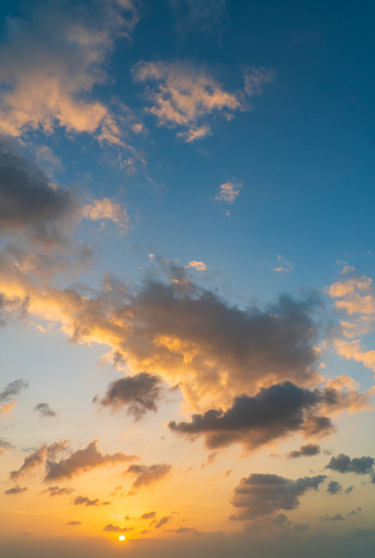 Sunny sky over sea in the evening with colorful sunlight and cloudy, dusk sky vertical.