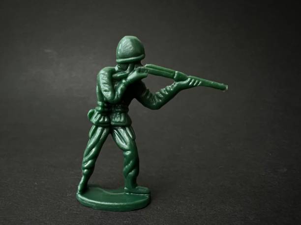 istock Soldier puppet holding gun towards enemy (black background), war concept. 1401095657