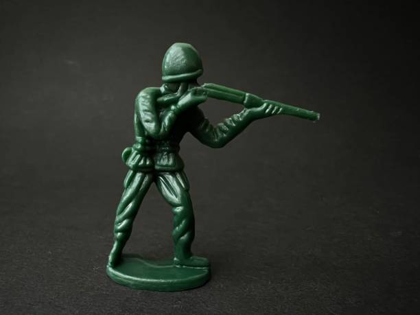 istock Soldier puppet holding gun towards enemy (black background), war concept. 1401095658