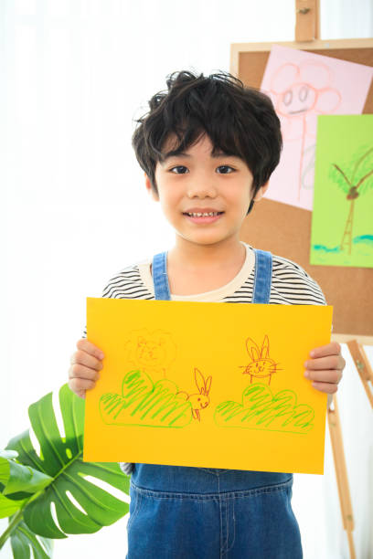 istock Happy little boy showing his drawing. 1401098937