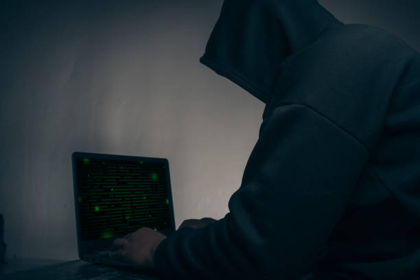 istock The hacker was wearing a black hoodie. Stealing huge financial data on computers with binary code digital interface.Hacking and malware concept. 1401103818