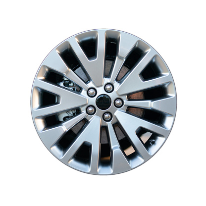 Modern new car rim on the car with visible brake disc and caliper - isolated against a white background