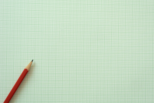 close up red pencil on graph paper background, education concept