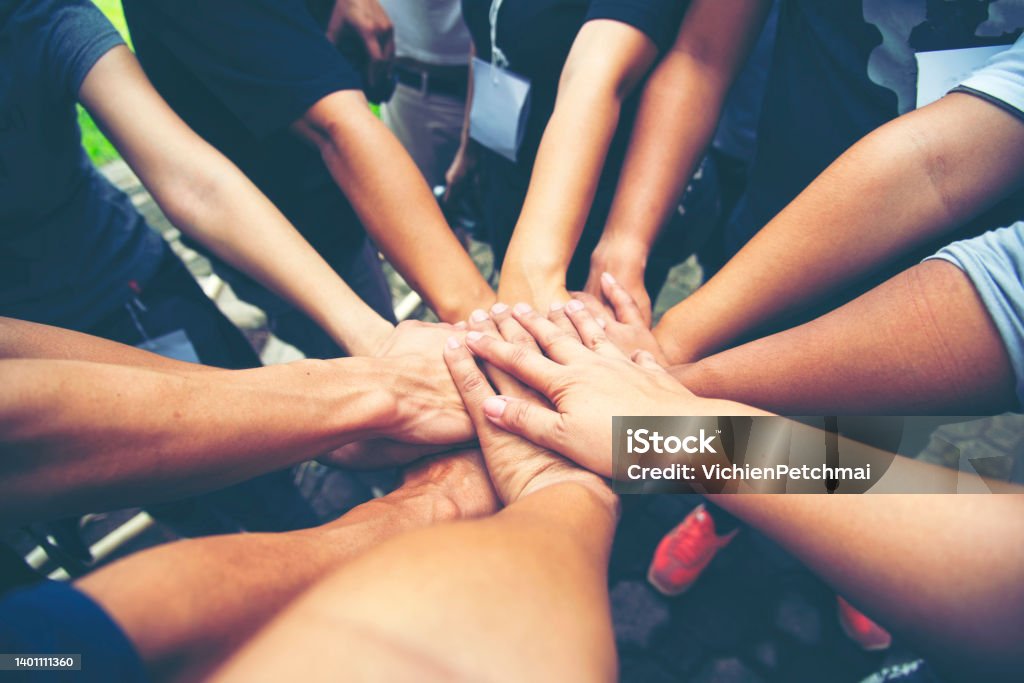 Teamwork Hands of spirit team working together outdoor. Unity strong handshake with people or agreement of feeling or happy diverse education action Teamwork Hands of spirit team working together outdoor. Unity strong handshake with people or agreement of feeling or happy diverse education action"n Unity Stock Photo