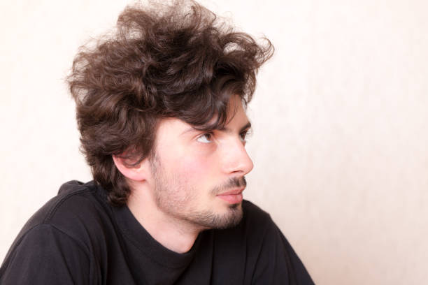 studio portrait of a curly haired man close up