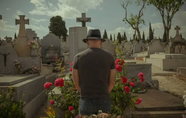 Rear view of adult man mourning in cemetery. Madrid, Spain