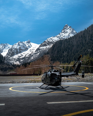 Helicopter landed on a base on the helipad in the mountains