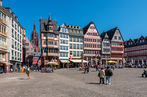 Frankfurt, Germany - April 20, 2022: Römerberg is part of the old town of Frankfurt. It is famous for the half-timbered houses and Cathedral Saint Bartholomew. Always many tourists are around.