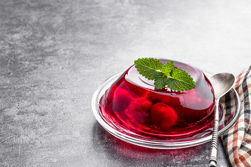 Fruit  jelly with fresh cherry on gray background