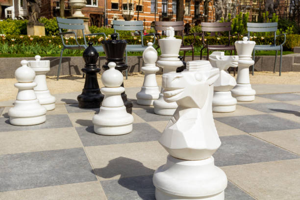Empty park with big chess figures and empty chairs on background.Nobody playing in real games.