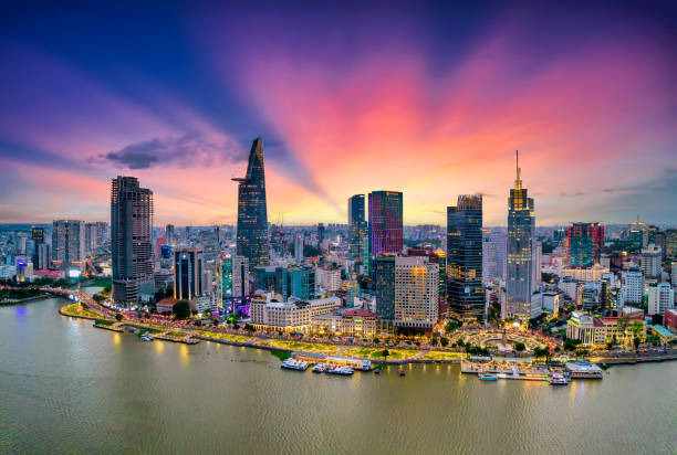 Aerial view of beautiful skyscrapers along the river at sunset sky Aerial view of beautiful skyscrapers along the river at sunset sky light flowing down urban development in Ho Chi Minh City, Vietnam. ho chi minh city stock pictures, royalty-free photos & images