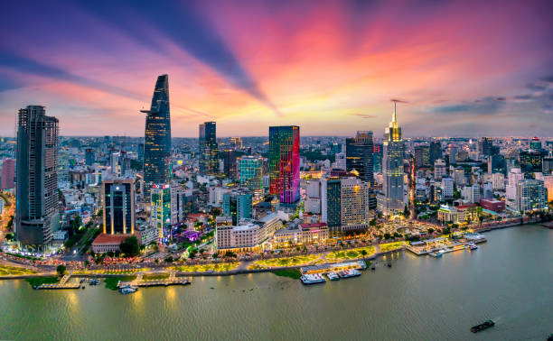 Aerial view of beautiful skyscrapers along the river at sunset sky Aerial view of beautiful skyscrapers along the river at sunset sky light flowing down urban development in Ho Chi Minh City, Vietnam. ho chi minh city stock pictures, royalty-free photos & images