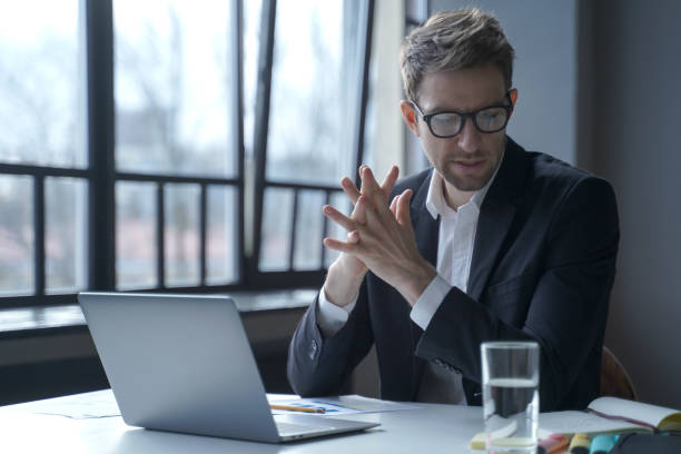 istock Brooding concentrated German businessman in formal suit and glasses sitting in office 1401127690