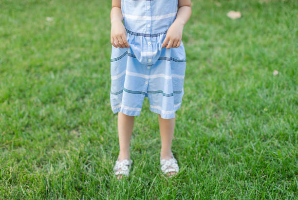 Little Girl Standing on Grass with Sandals