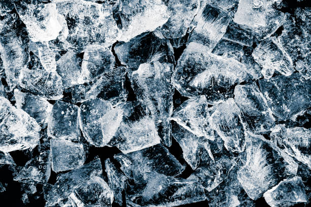 istock Pieces of crushed pure ice cubes on black background. Refreshing textured ice background. 1401128944