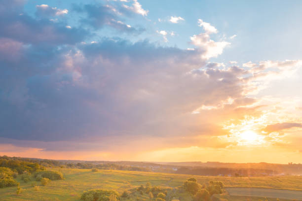 Sunset over rural landscape, last rays of sunlight illuminate a silhouetted landscape, Tuscany