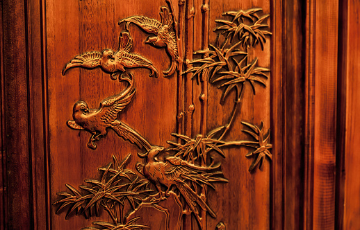 Wood sculpture in Thai style located at the window of traditional Thai house.