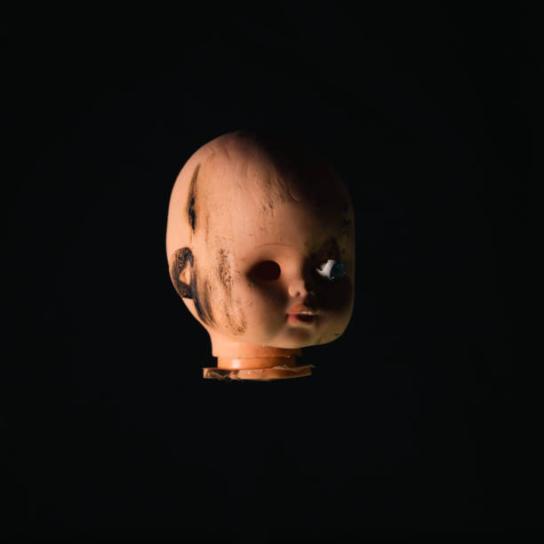 Doll head on black background
