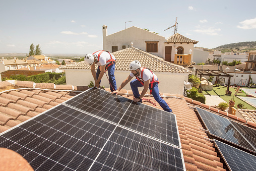 Men installing solar panel in sunny day