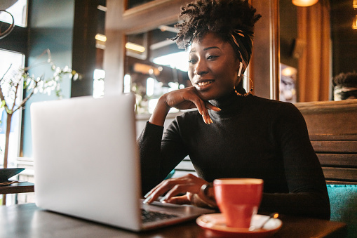 A young African woman having a work meeting call in a cafe.