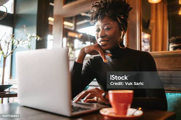 African Woman On A Online Meeting In A Cafe Stock Photo - Download Image Now - Young Adult, Entrepreneur, Laptop