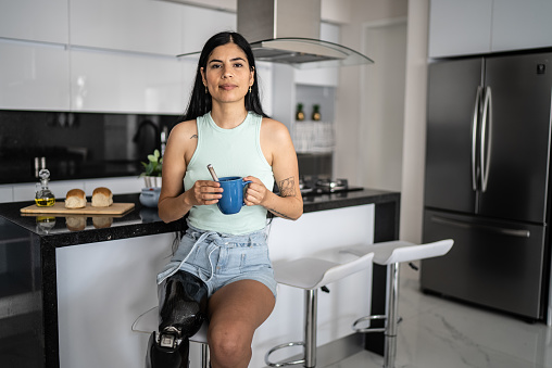 Portrait of disabled woman drinking coffee at home