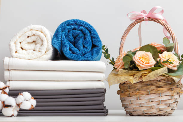 istock A stack of bed linen sheets bedding rolls of towels. Basket with roses flowers on the table. 1401137521