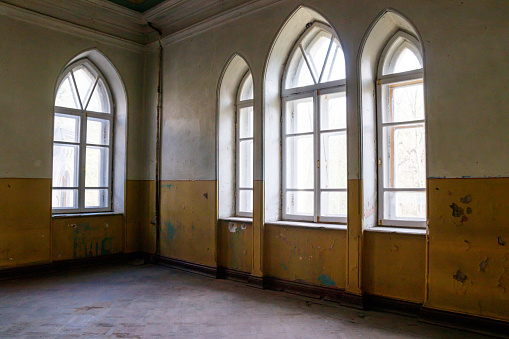 Famous abandoned ruined hospital located near Berlin. Broken windows, damaged structure. Desaturated and grainy for the mood.