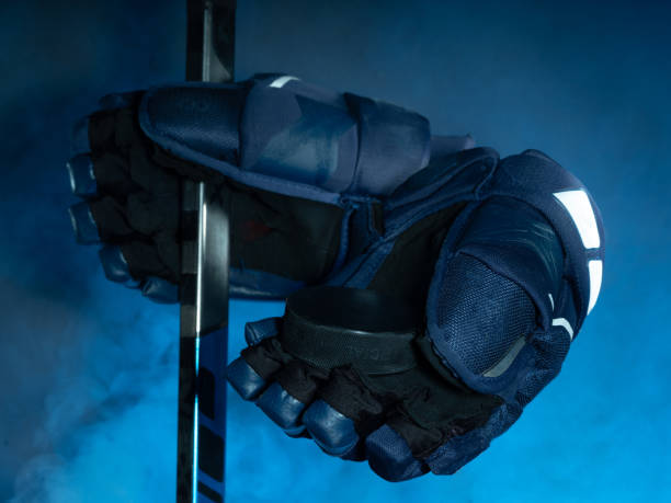 Closeup of ice hockey equipment against a smoky background. Hockey puck, ice hockey stick, ice hockey gloves stock photo