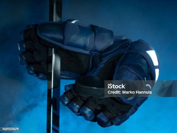 Closeup Of Ice Hockey Equipment Against A Smoky Background Hockey Puck Ice Hockey Stick Ice Hockey Gloves Stock Photo - Download Image Now