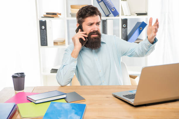 istock Stressed lawyer yelling on mobile phone working on laptop in office, stress 1401137965