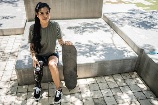 Portrait of a disabled skateboarder woman at the park