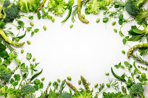 Raw green vegetables and fresh herbs arranged in a frame. Cooking clean eating concept. Healthy food.Top view.