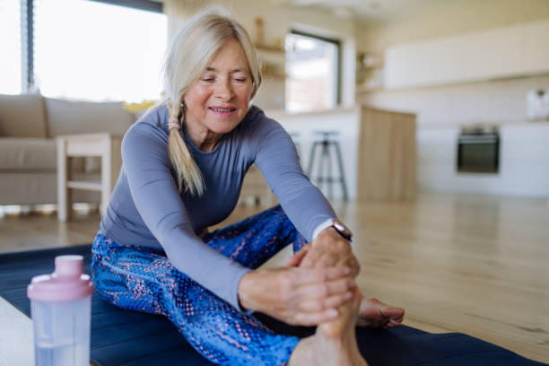 istock Fit senior woman doing stretching exercise at home, active lifestyle concept. 1401142064