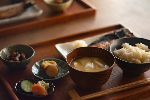 Healthy traditional Japanese breakfast in the 'ichiju-sansai' that has three dishes (one main dish and two side dishes) served on the table.
