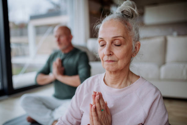 istock Senior couple doing relaxation exercise together at home. 1401144834