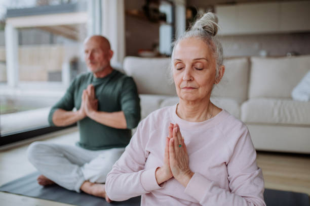 istock Senior couple doing relaxation exercise together at home. 1401144849