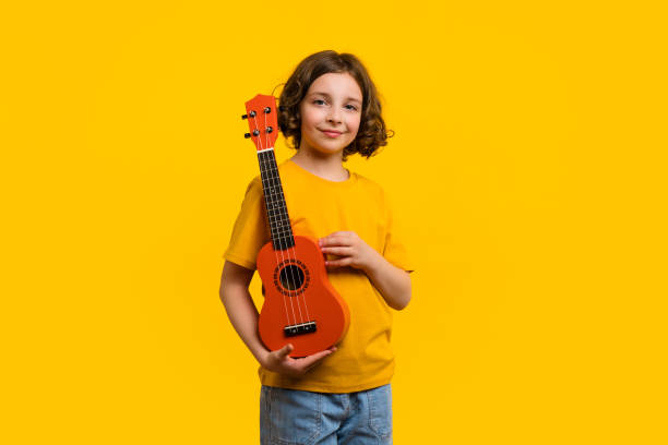 istock Child girl with ukulele in studio 1401144943
