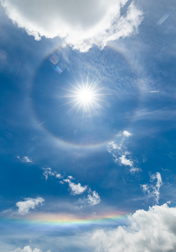 A ring around the sun with a flat section of a rainbow below.