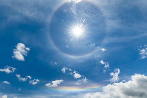 A ring around the sun with a flat section of a rainbow below.