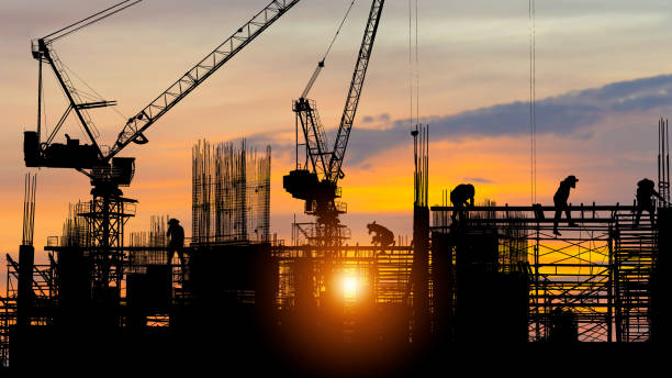 istock Silhouette of Engineer and worker on building site, construction site at sunset in evening time 1401145973