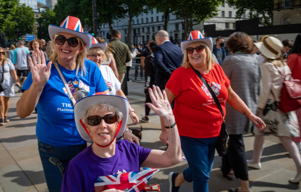 trois femmes royalistes vêtues de drapeaux unioin agitent alors qu’elles assistent à des événements pour le jubilé de platine de la reine à londres. - queen jubilee crowd london england photos et images de collection