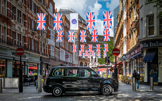 A TX City electric black cab waits for passengers under Jubilee bunting in central London